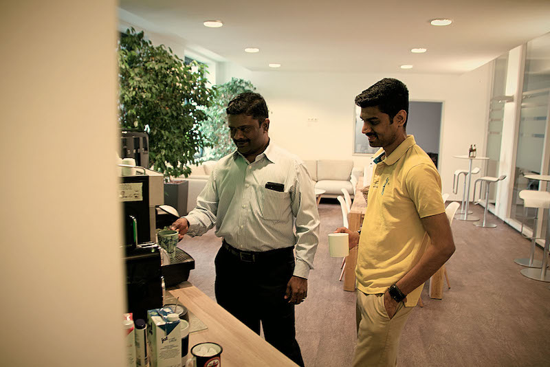 Hi, Wir sind Neos Neos IT Services, Arbeitsumgebung, Mitarbeiter an der Kaffeemaschine