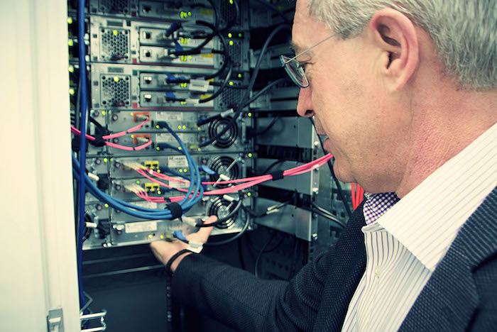 Neos IT Services, Arbeitsumgebung, Mitarbeiter vor dem Serverschrank