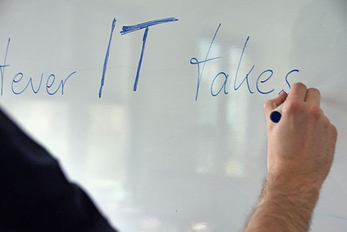 Neos IT Services, Arbeitsumgebung, Mitarbeiter vor einem Whiteboard - Whatever IT takes